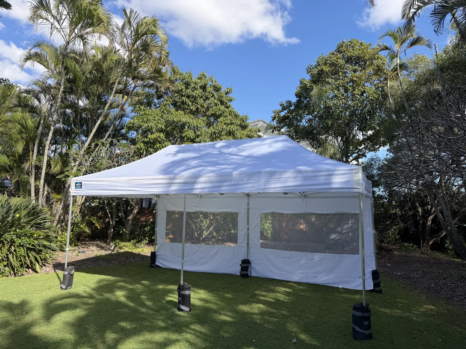 White party gazebo with window sidewalls on a Gold Coast lawn